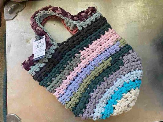 a multicolored crocheted bag sitting on top of a table.