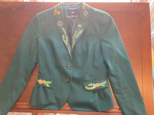 A green blazer with hand-painted flowers on it.