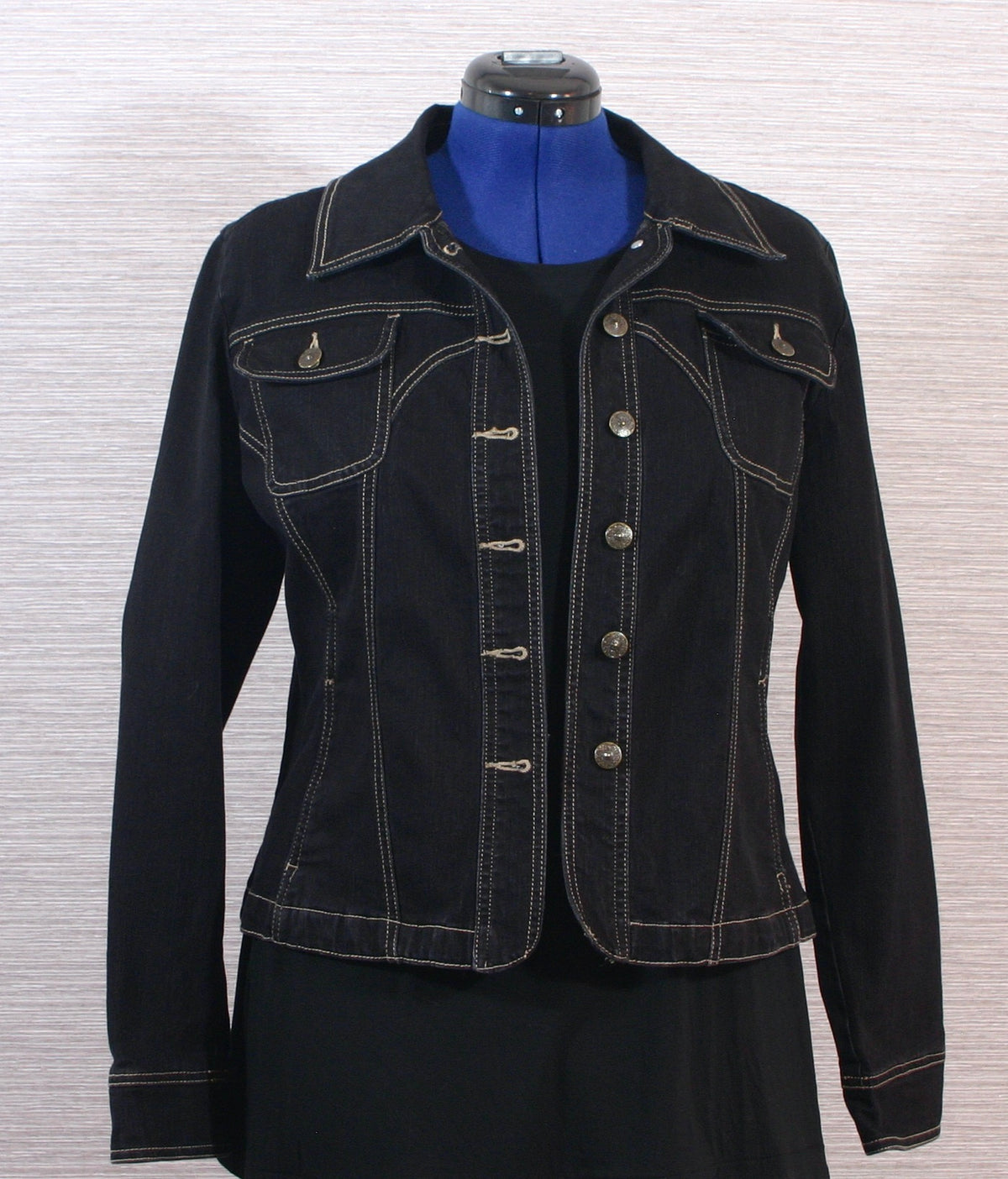 A black denim jacket on a mannequin dummy.