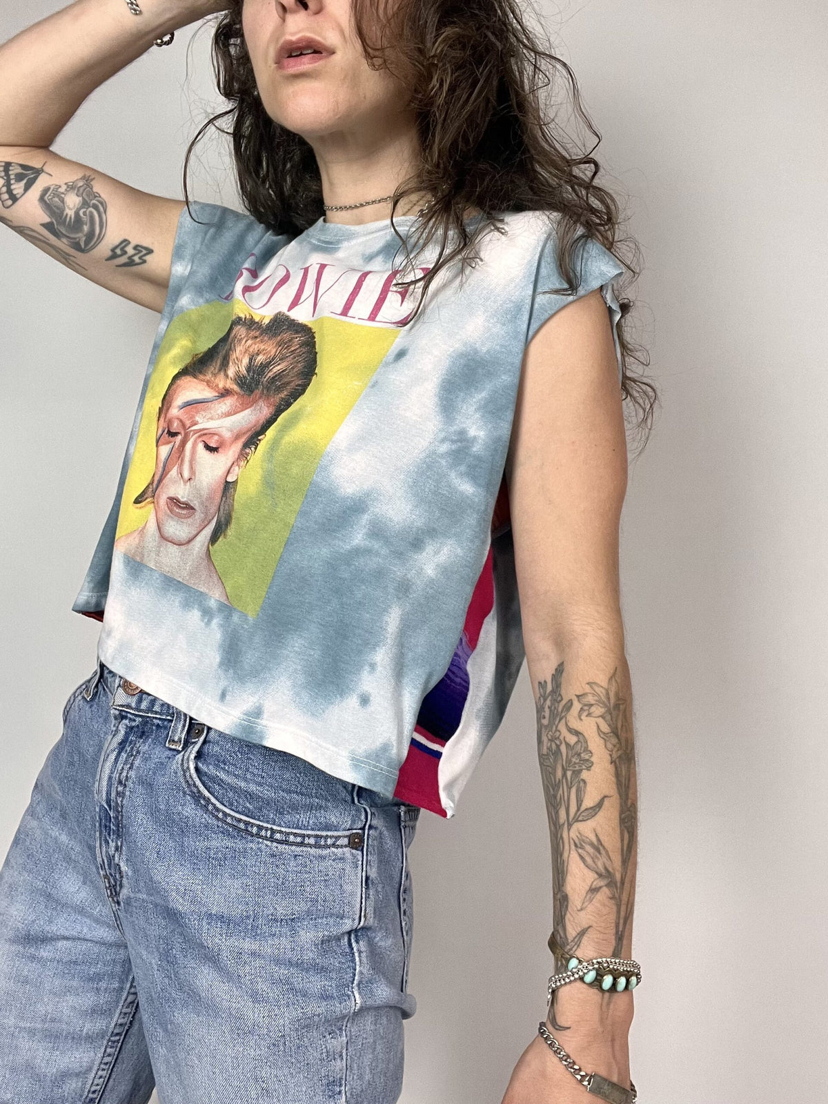 a woman wearing a tie dye shirt with a picture of a man on it.