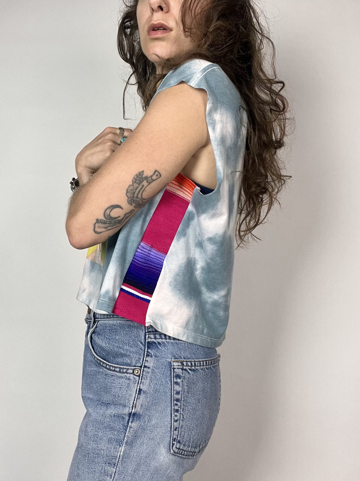 a woman with long hair wearing a tie dye shirt.