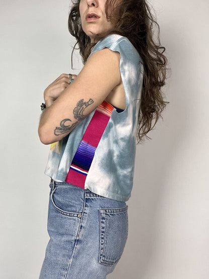 a woman with long hair wearing a tie dye shirt.