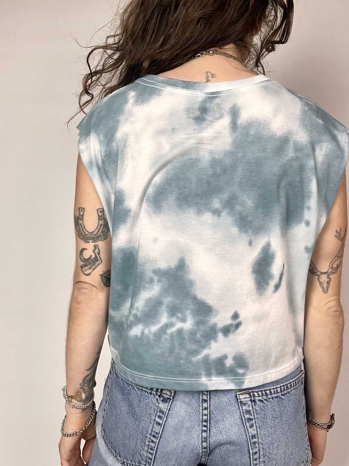 a woman wearing a blue and white tie dye shirt.