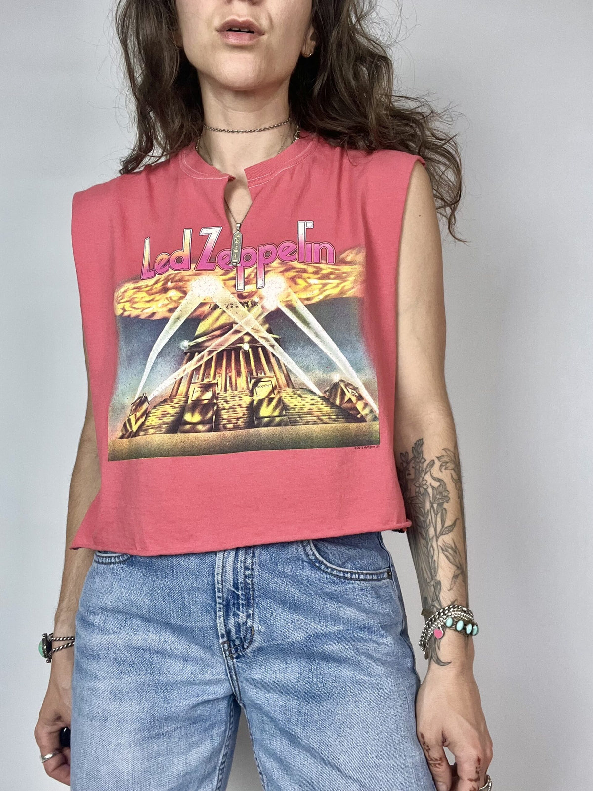 a woman wearing a pink shirt and jeans.
