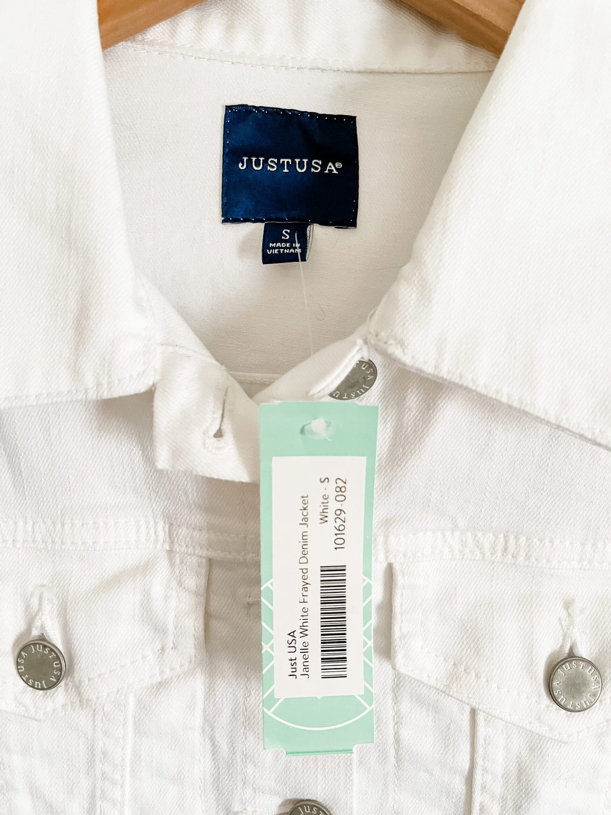 A white denim jacket with a tag on it.