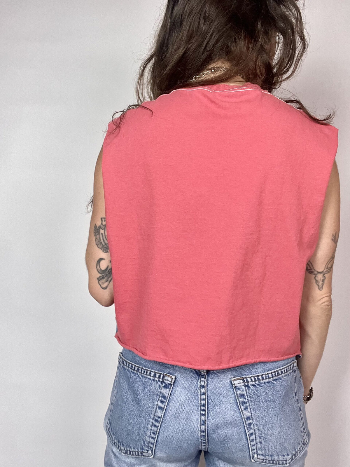 a woman wearing a pink shirt and jeans.