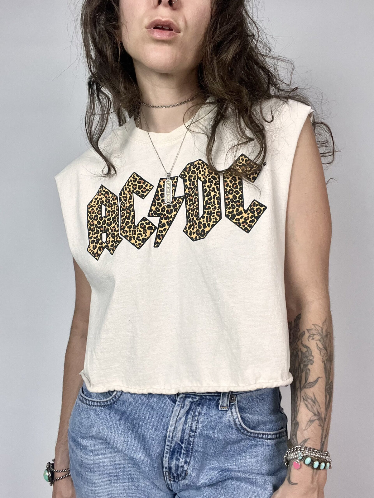 a woman with long hair wearing a white shirt and jeans.