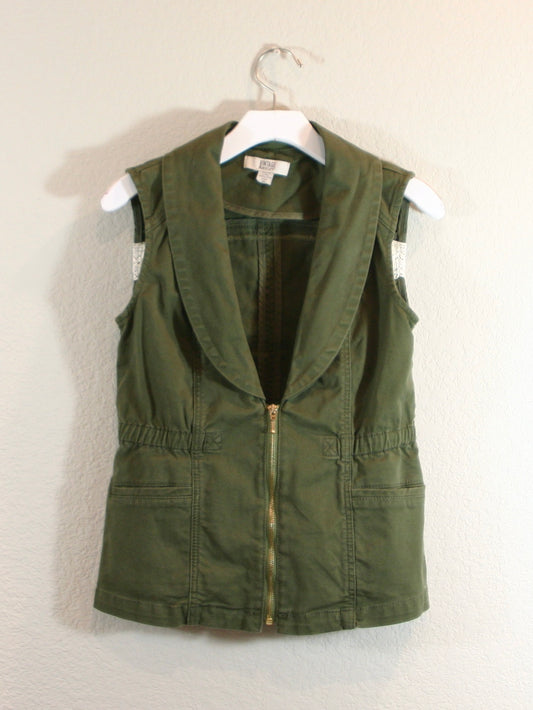 A green vest hanging on a wall.