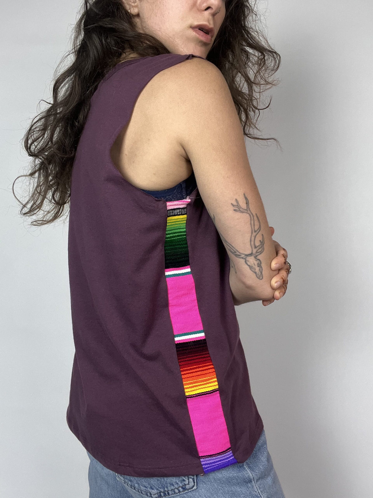 a woman with long hair wearing a purple shirt and a colorful tie.