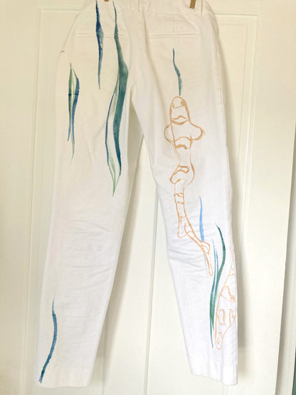 a pair of white pants hanging on a door.