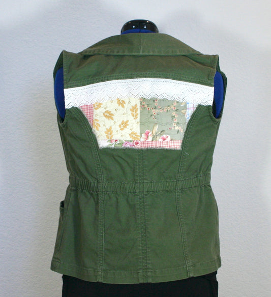 A green vest with patchwork on the back.