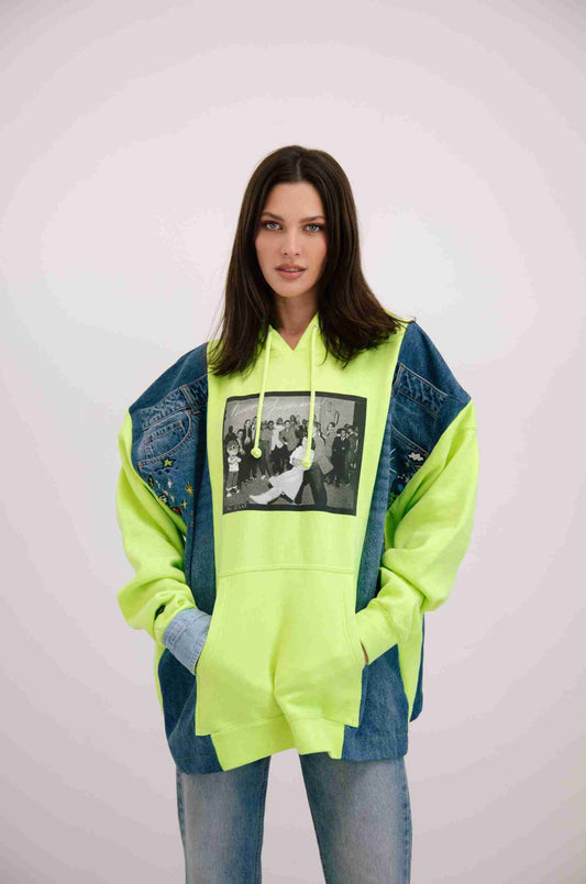 a woman wearing a neon green hoodie with a black and white photo on it.