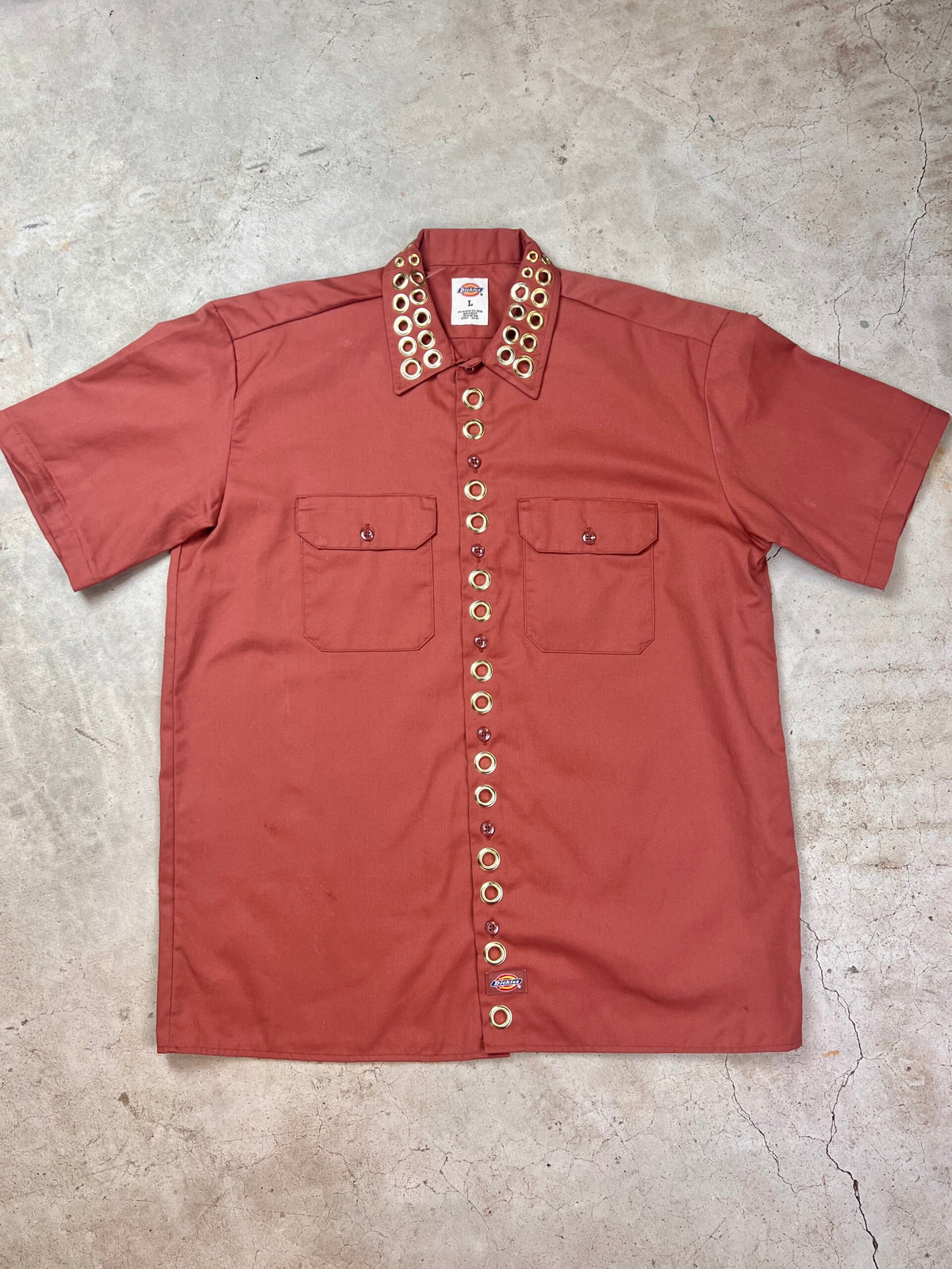 A red shirt on a concrete surface.
