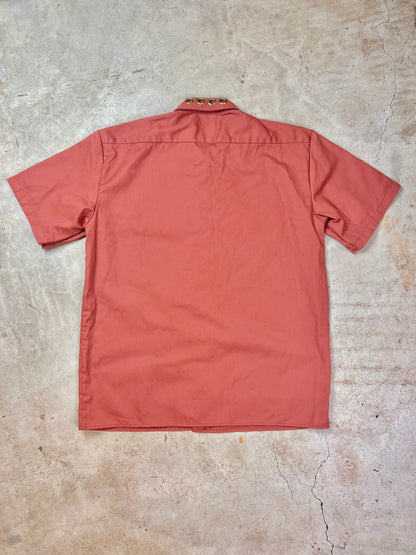 The back of a red shirt on a concrete floor.