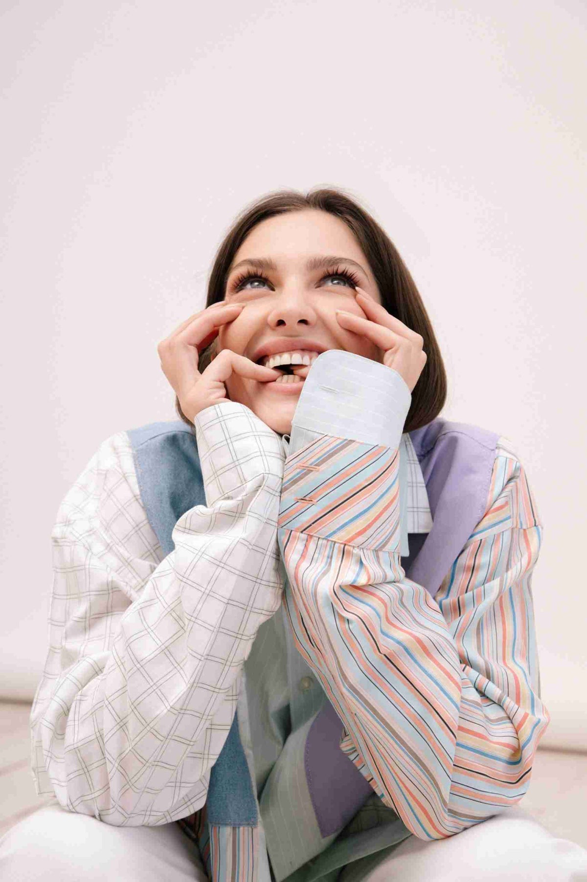 a woman sitting on the floor with her hands on her face.
