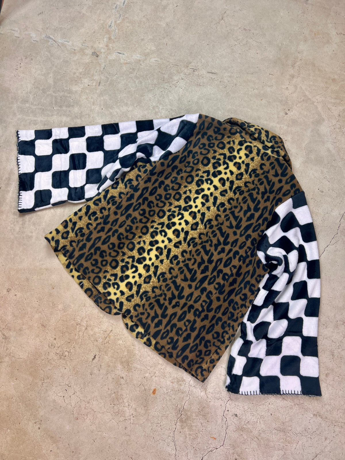 A leopard print coat on a concrete surface.