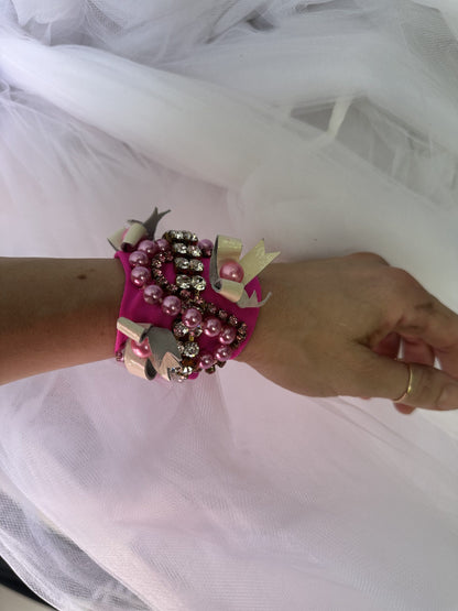 A woman wearing a pink bracelet on her wrist.