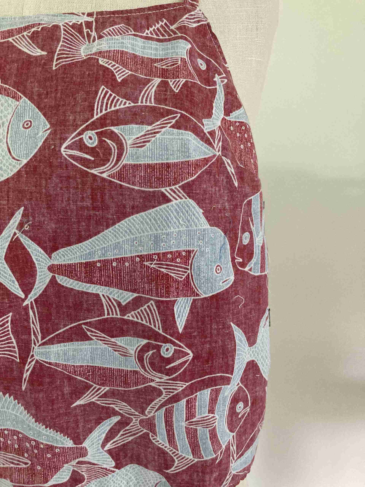 a red and white pillow with fish on it.
