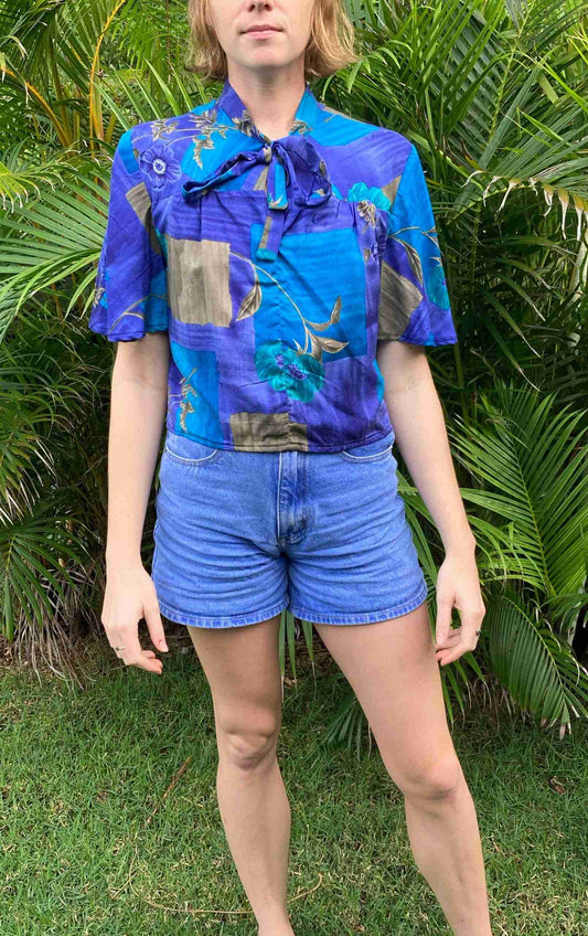 a woman standing in front of a bush.