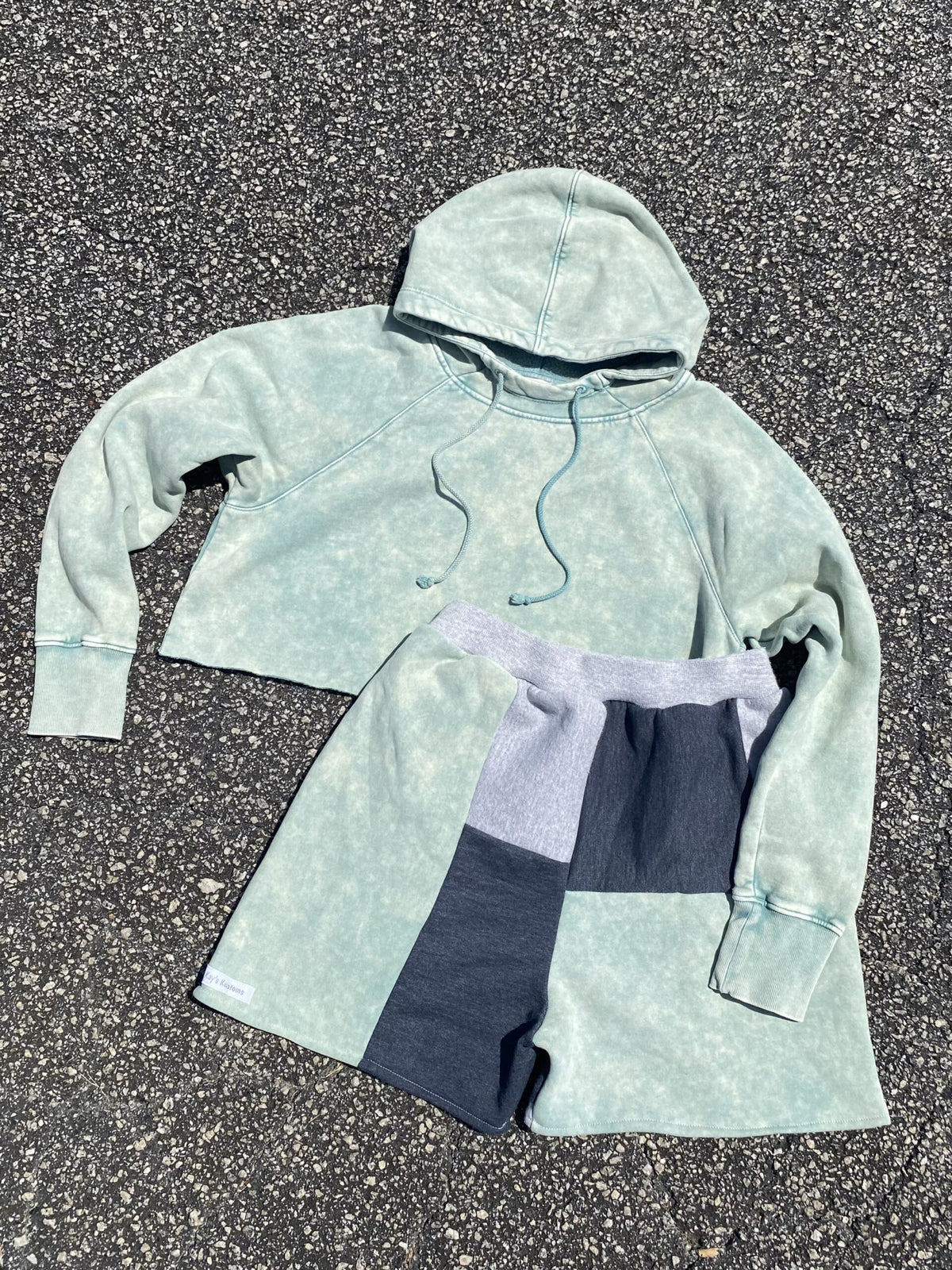 A pair of shorts and a hoodie on the ground.
