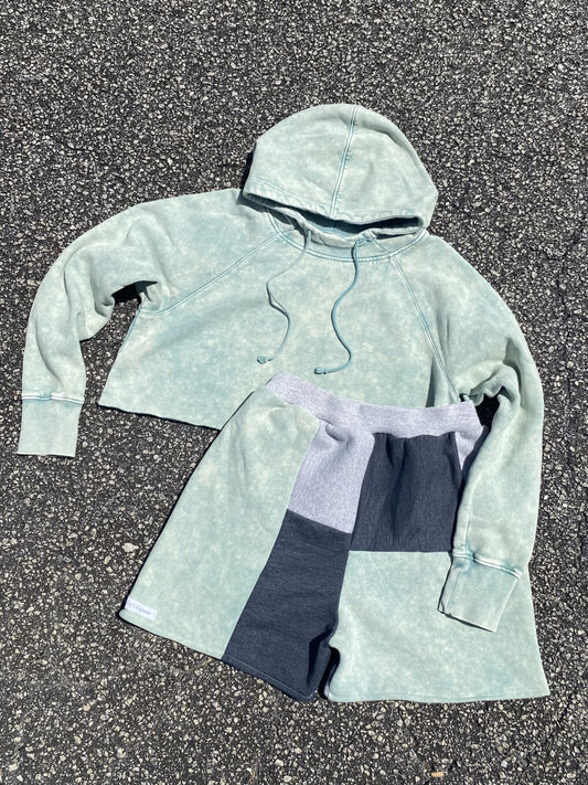 A pair of shorts and a hoodie on the ground.