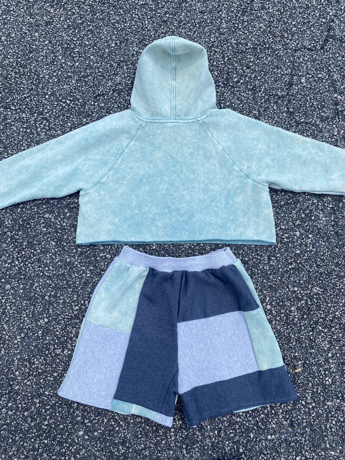 A blue hoodie and shorts on the ground.