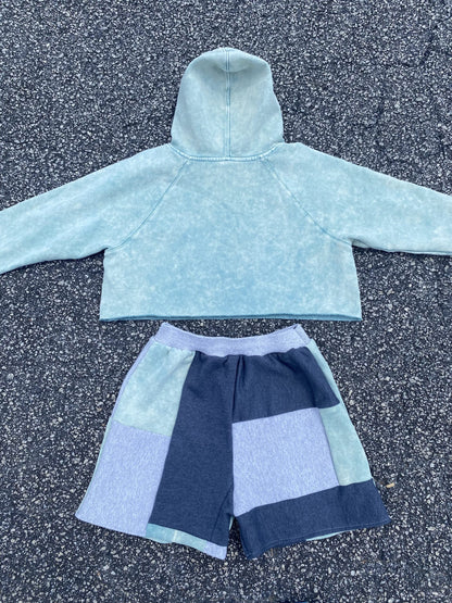 A blue hoodie and shorts on the ground.