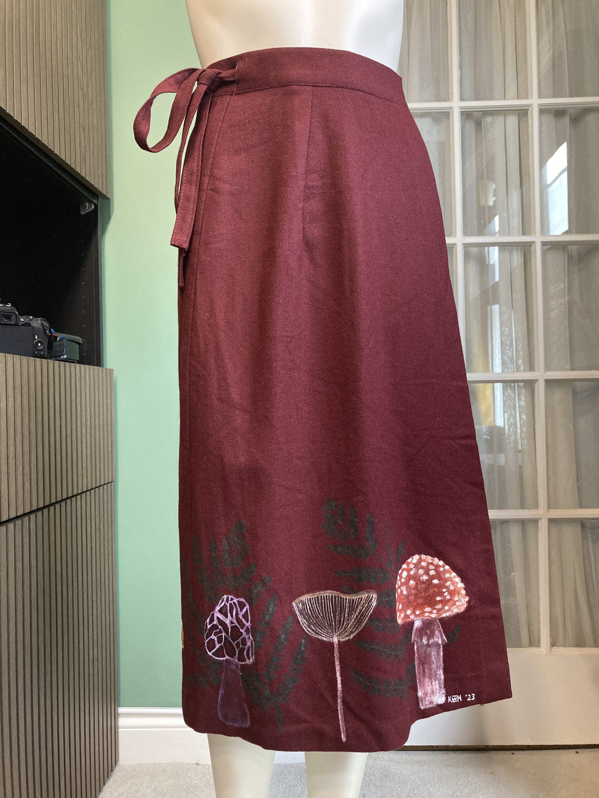 A mannequin wearing a skirt with mushrooms on it.