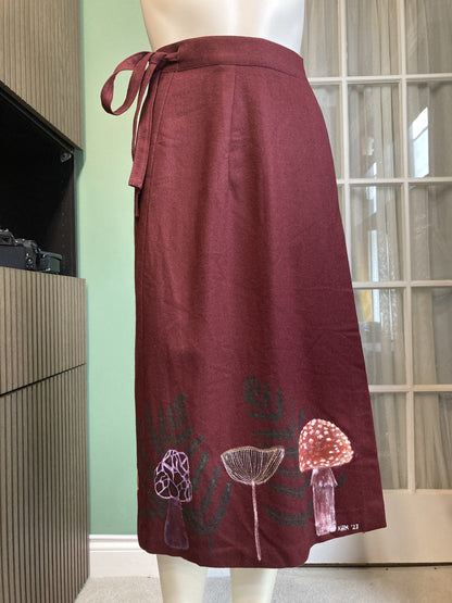A mannequin wearing a skirt with mushrooms on it.