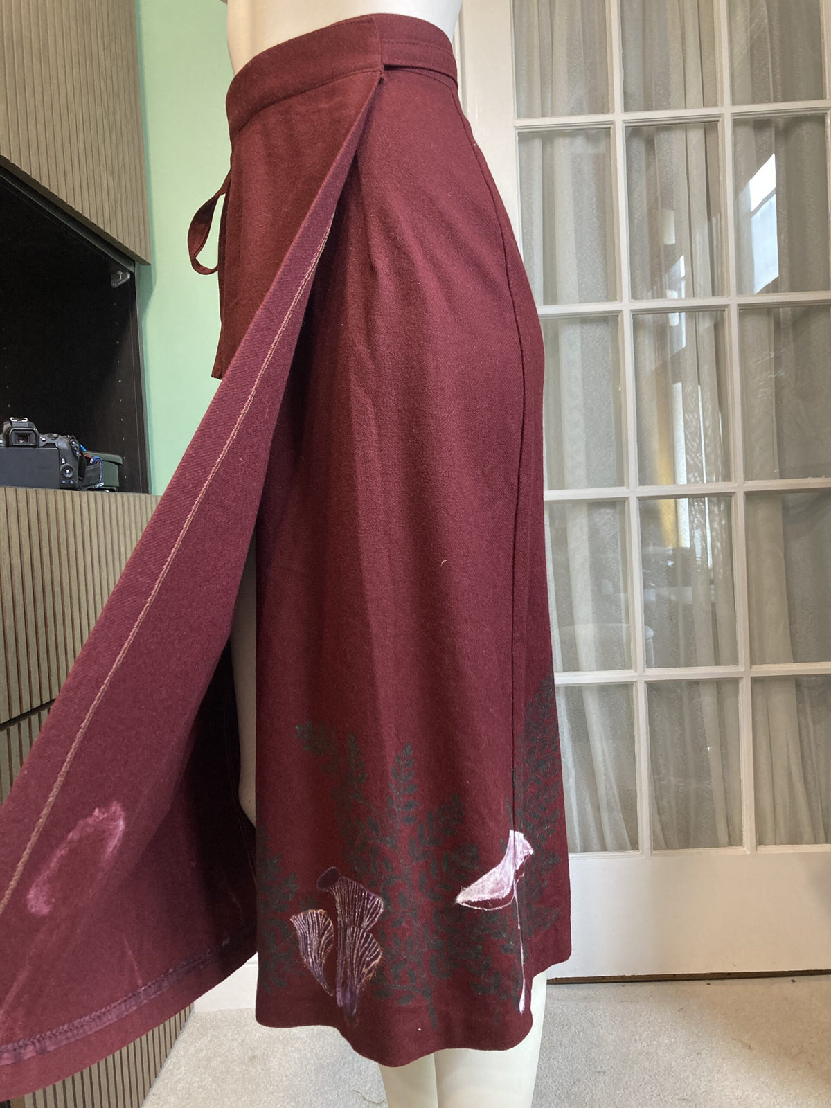 A mannequin wearing a burgundy skirt.