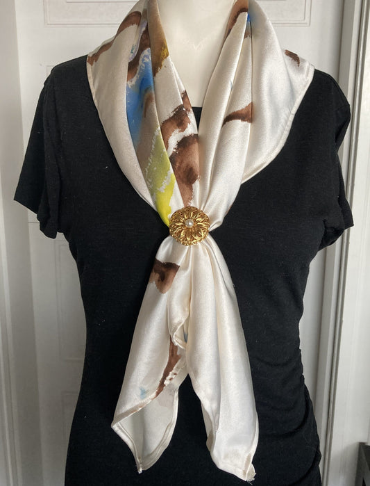 A white silk scarf with a gold buckle.