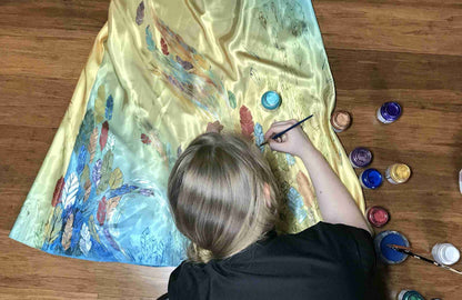a woman is painting a picture on the floor.