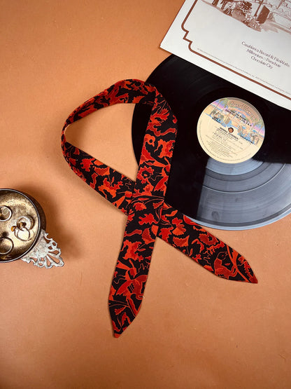 a record and a red ribbon on a table.