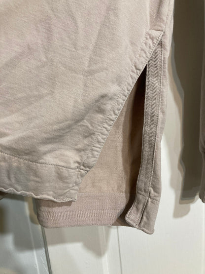 A close up of a beige hoodie hanging on a door.