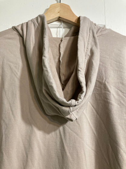 A beige hoodie hanging on a hanger.