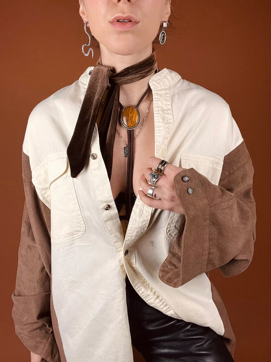 a woman wearing a white shirt and brown scarf.