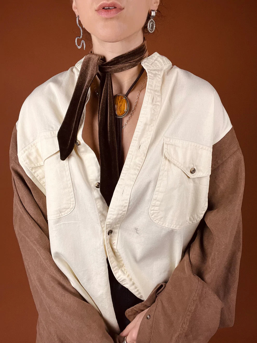a woman wearing a white shirt and brown tie.