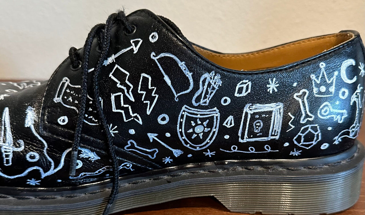 A black shoe with white drawings on it.