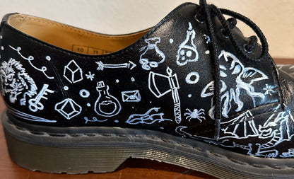 A black shoe with white drawings on it.