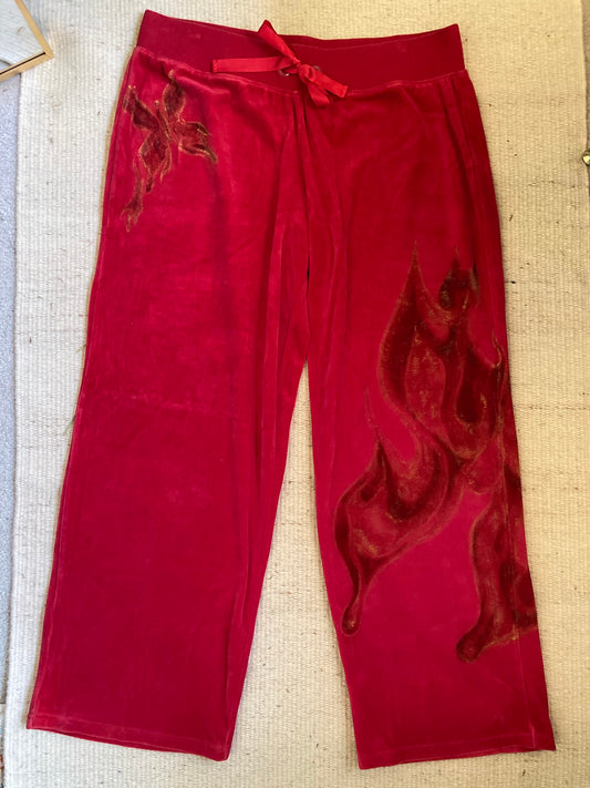 A pair of red sweatpants with a fire design on them.