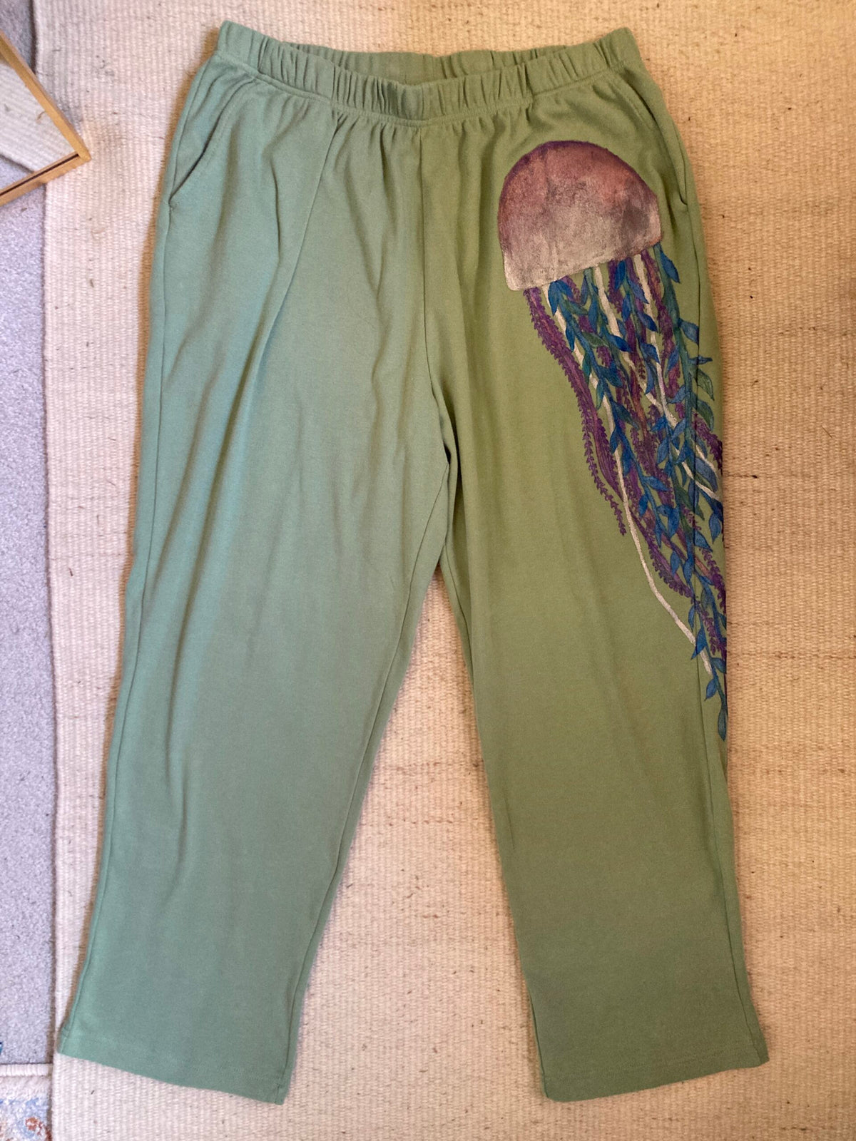 A pair of green pants with a jellyfish on them.