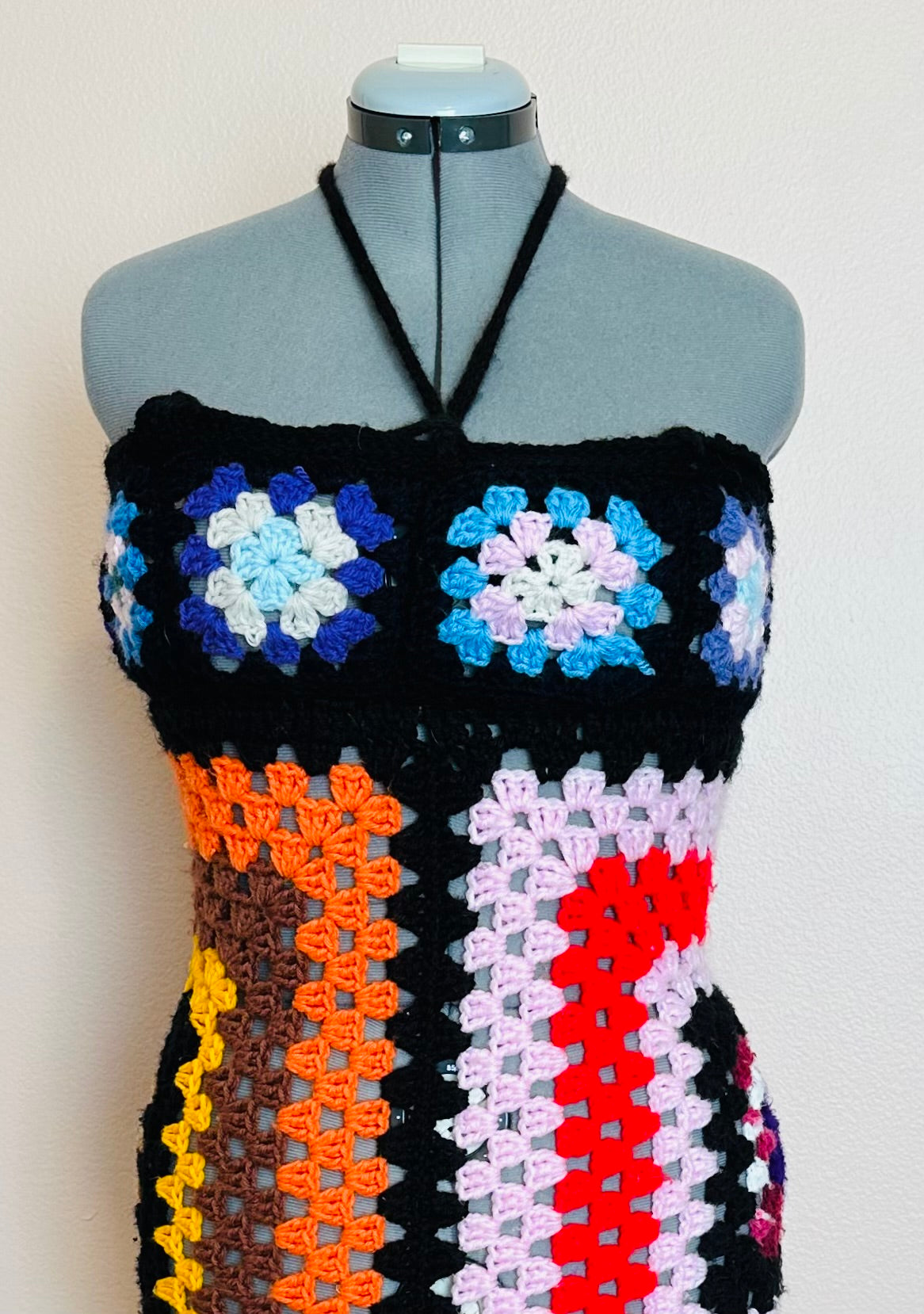 A crocheted top on a mannequin dummy.
