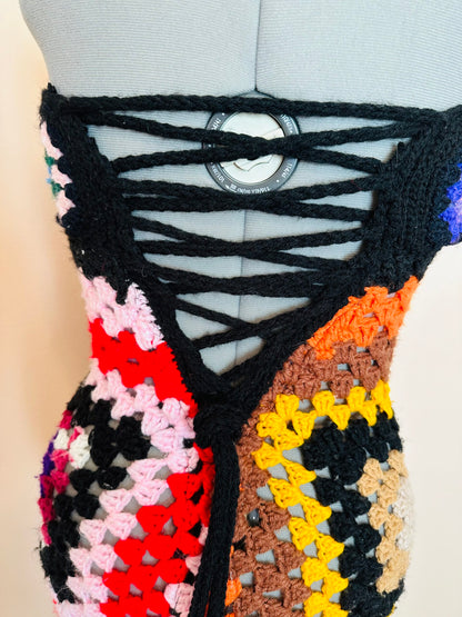 A colorful crocheted dress on a mannequin.