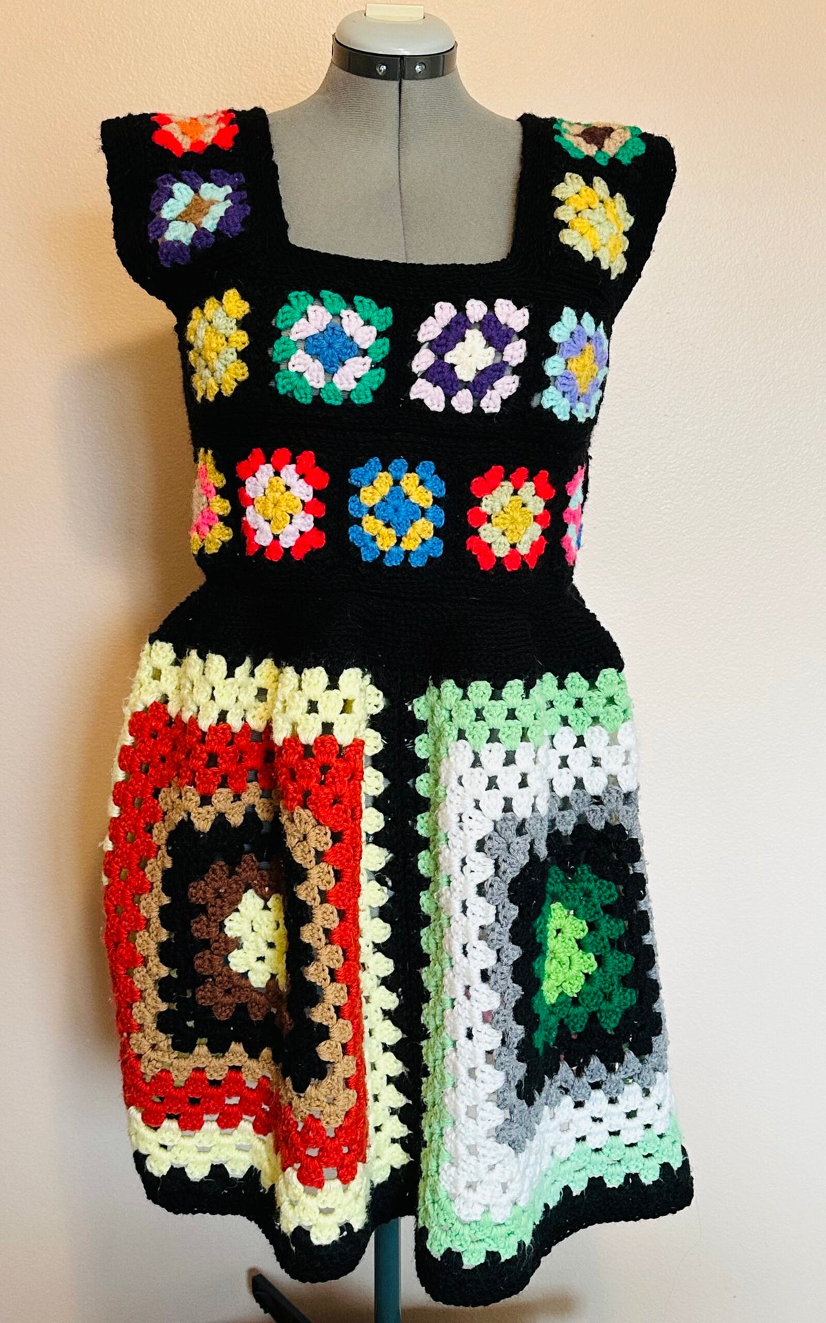 A crocheted dress on a mannequin dummy.