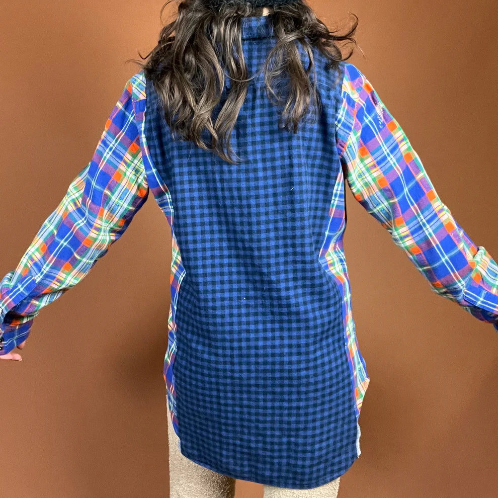 a woman with long hair wearing a blue plaid shirt.