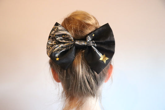 Woman wearing a large hand-painted black bow with stars