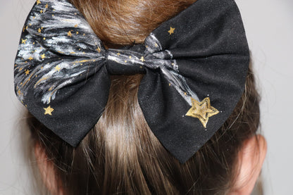 Woman wearing a large hand-painted black bow with stars
