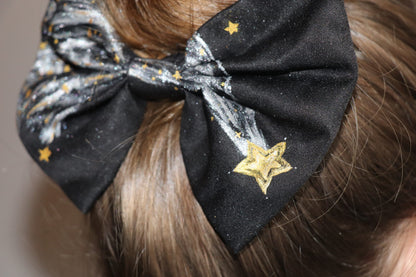 Woman wearing a large hand-painted black bow with stars