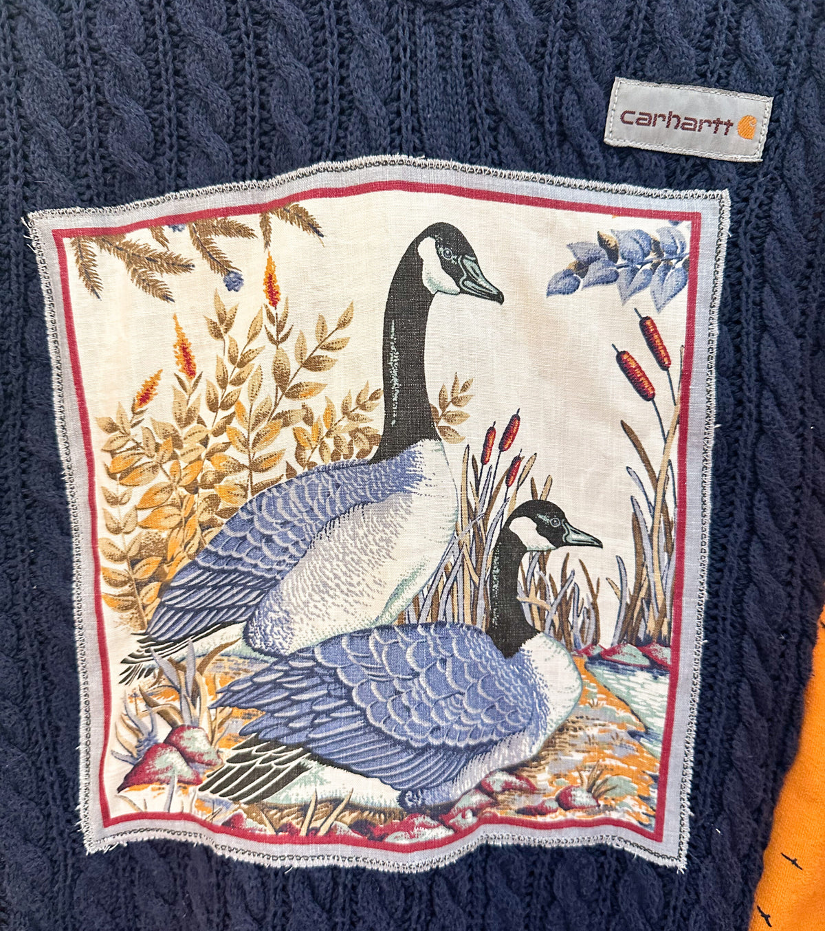 A sweater with two geese on it.