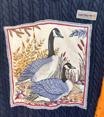 A sweater with two geese on it.